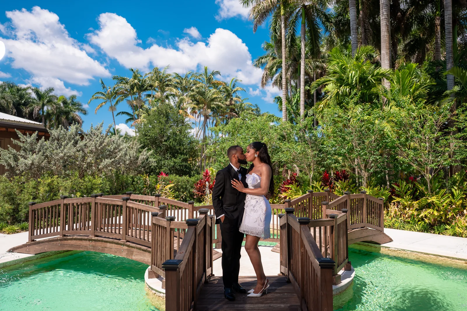 On the bridge — palms, turquoise water, and a kiss